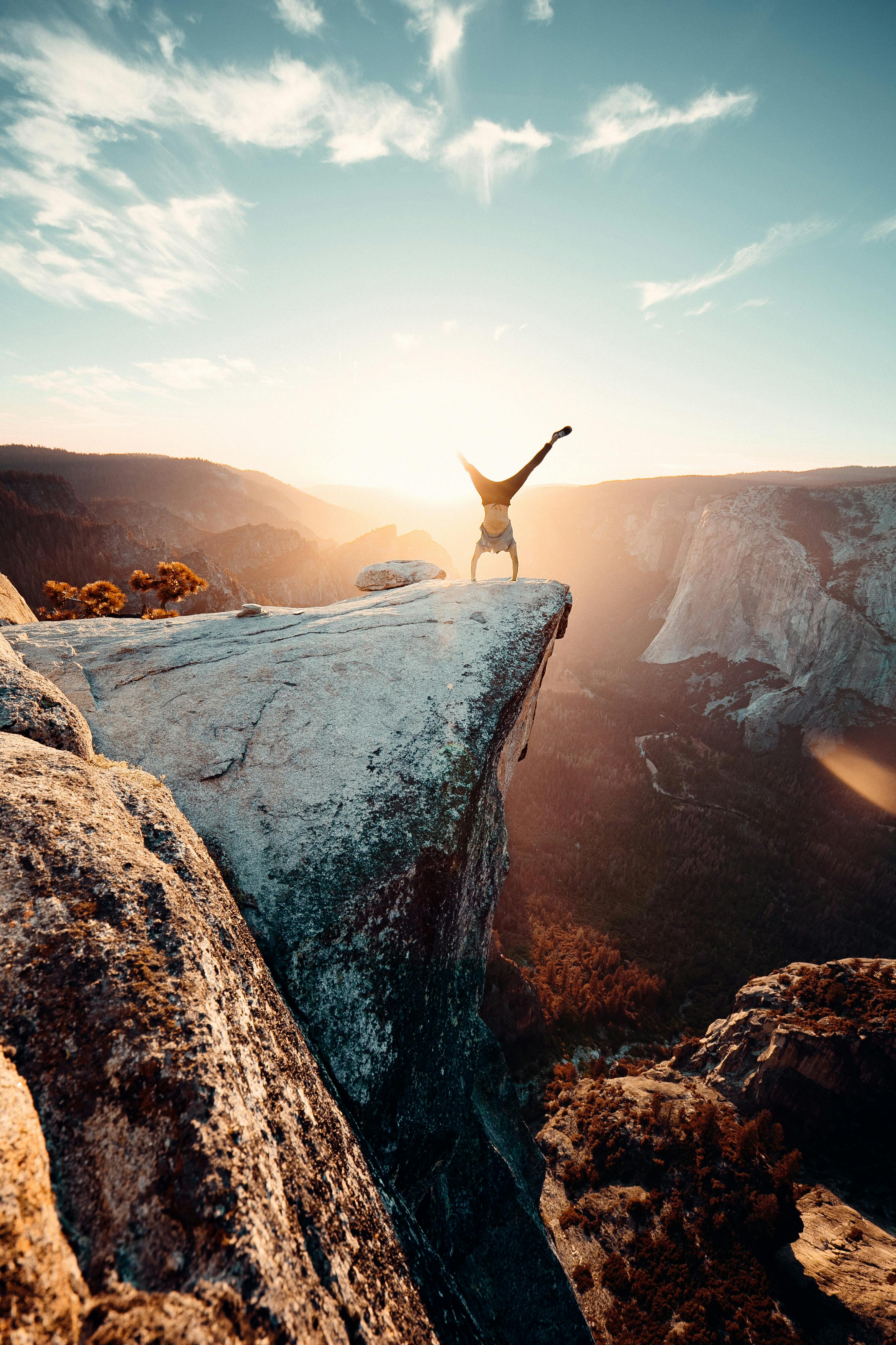 Adventurer Doing Handstand on Cliff Edge