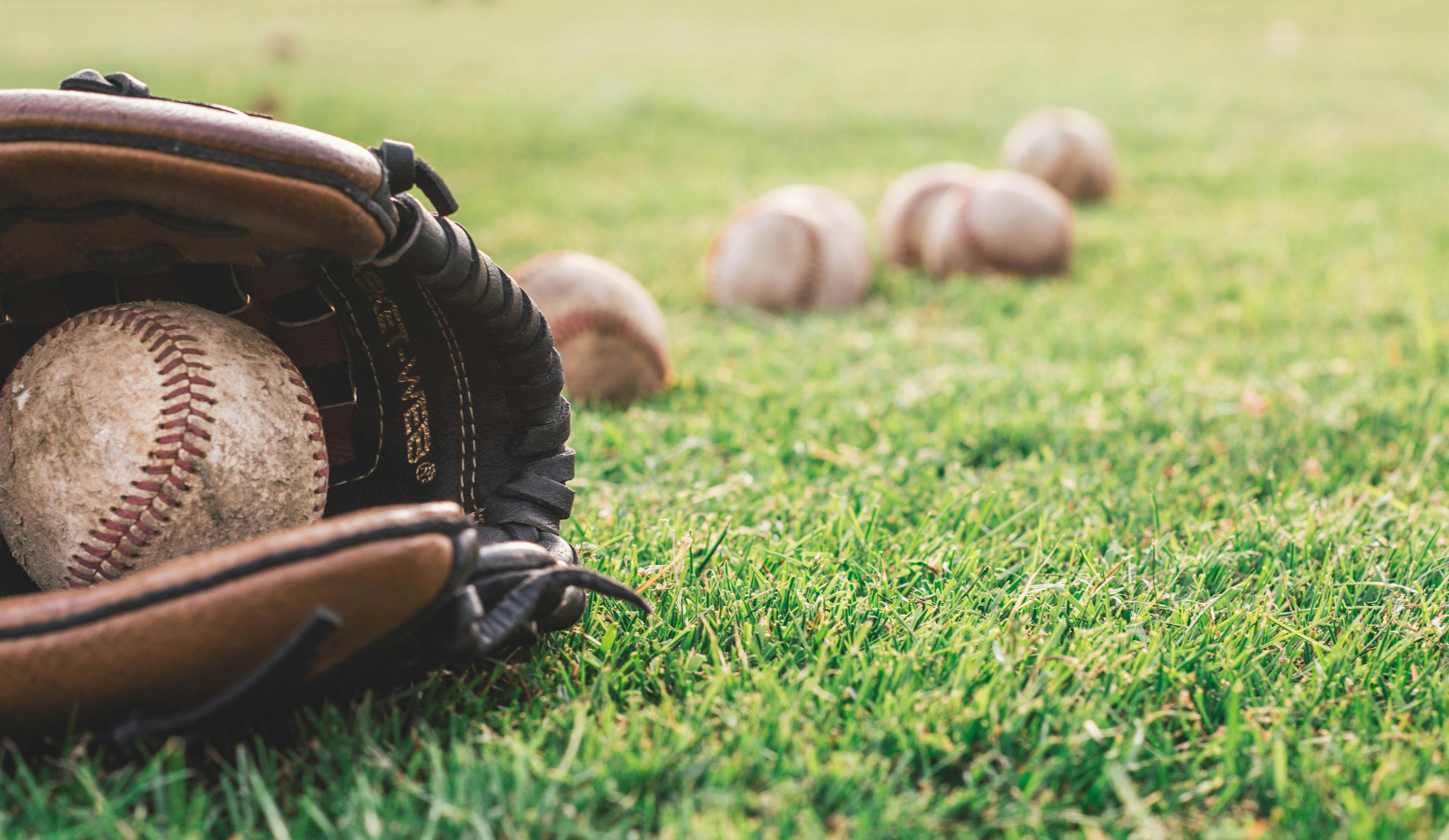 Baseball Glove and Balls on Field 